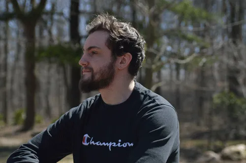 Headshot of myself sitting in a park looking off camera to the left.